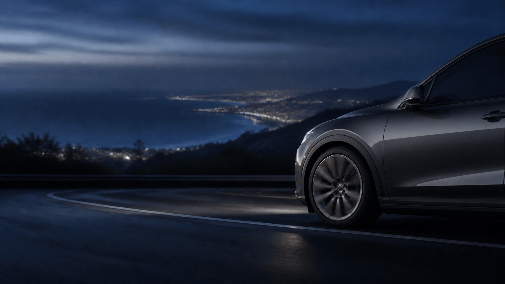 Car on a coastal road at night